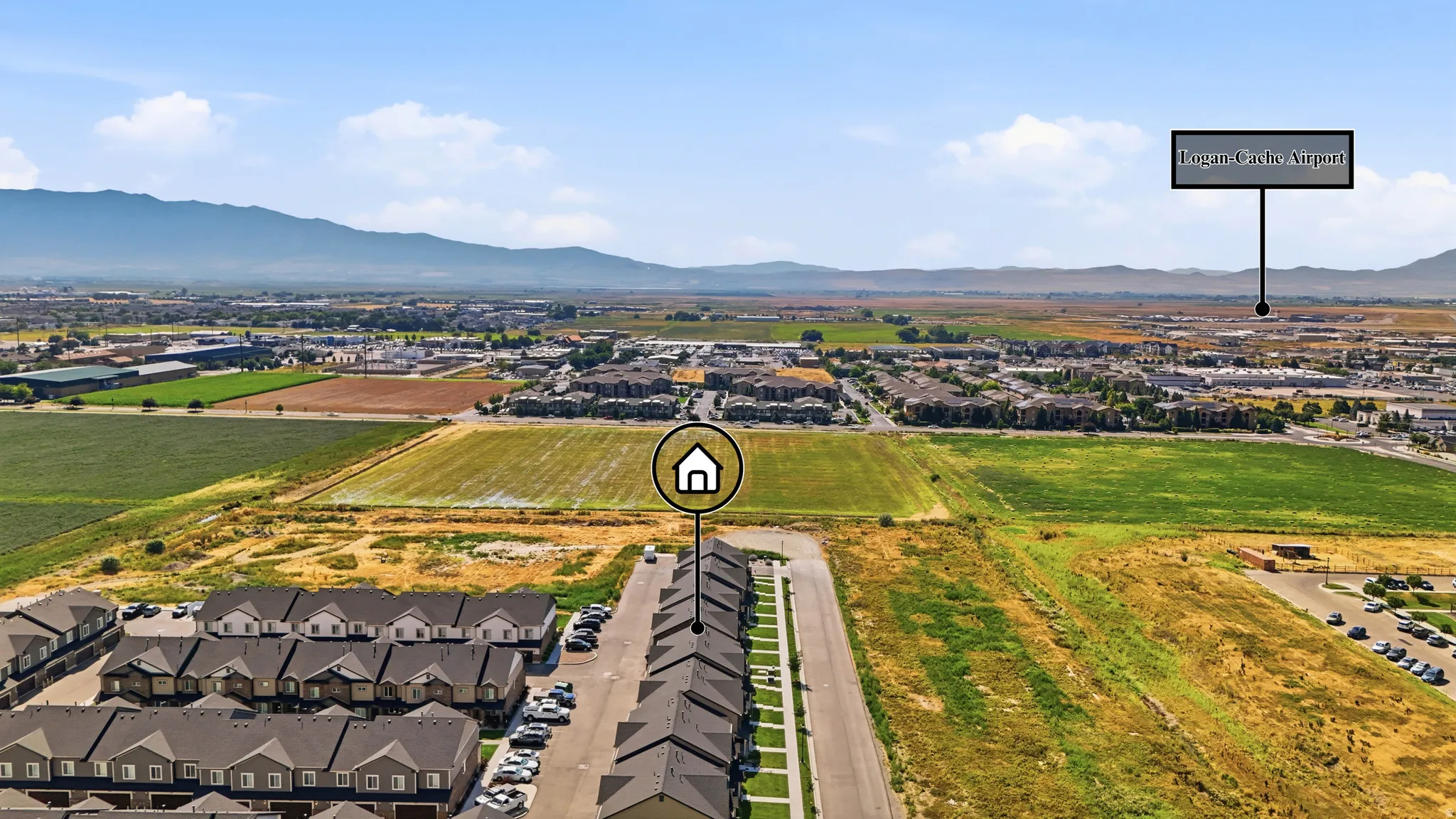 Aerial perspective showcasing a residential development with mountain backdrops and expansive open fields
