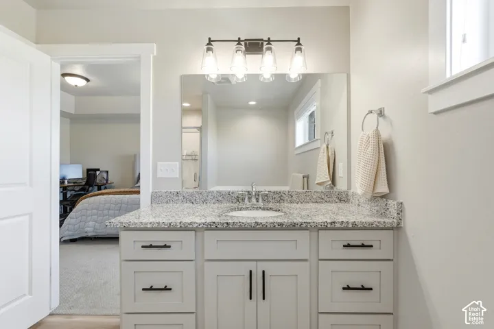 Vanity with a speckled countertop, undermount sink, and dark-finish hardware