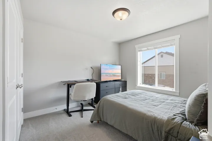 Carpeted room featuring a white-framed window, neutral painted walls, and a semi-flush mount ceiling light
