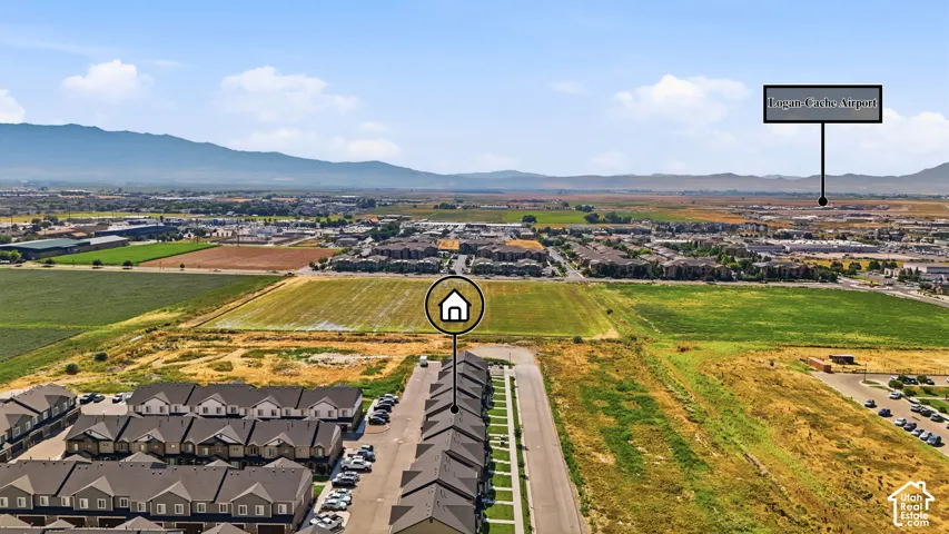 Aerial perspective showcasing a residential development with mountain backdrops and expansive open fields