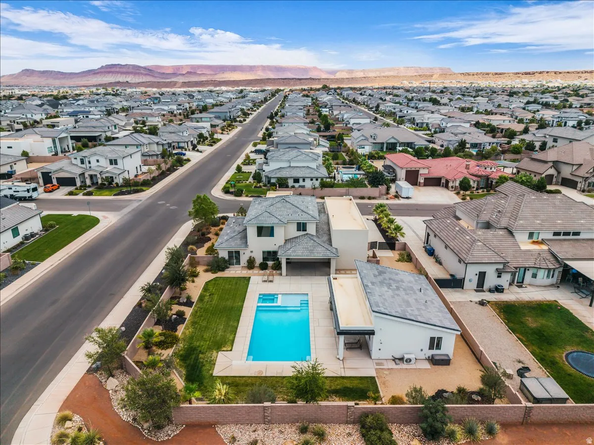 Modern residential property featuring a private swimming pool, manicured lawn, and an attached covered patio