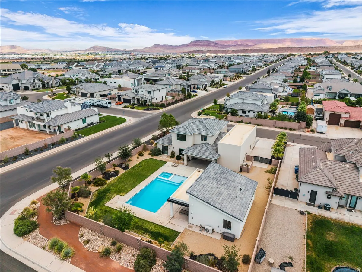 Custom property featuring a private swimming pool with an integrated spa, expansive green lawn, and a covered patio