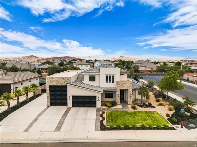 Contemporary stucco exterior with stone accents and a multi-car garage