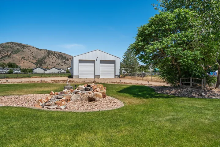 Expansive lawn featuring a decorative rock garden with a cascading water feature