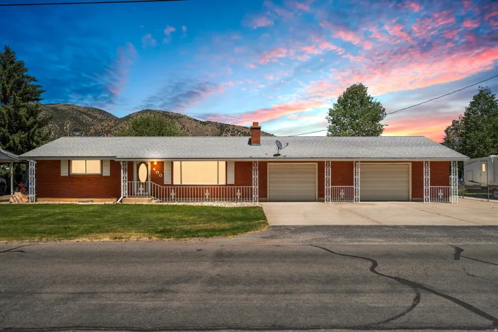Ranch-style residence featuring a brick facade, white trim, and a shingle roof