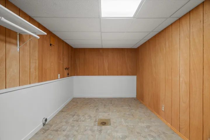 Room featuring wood-finish paneling walls and white wainscoting