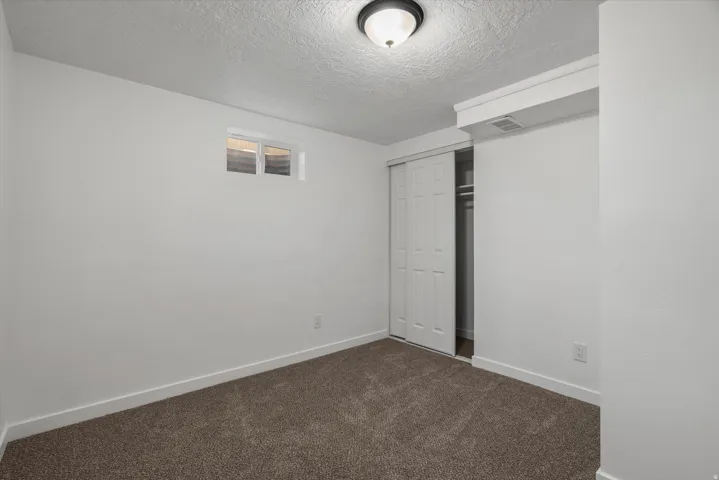 Room featuring neutral tone carpeting and white baseboards
