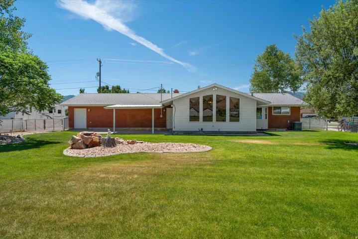Expansive green lawn with a decorative rock feature