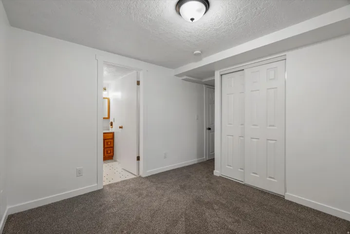 Carpeted room with white walls, baseboards, and ceiling