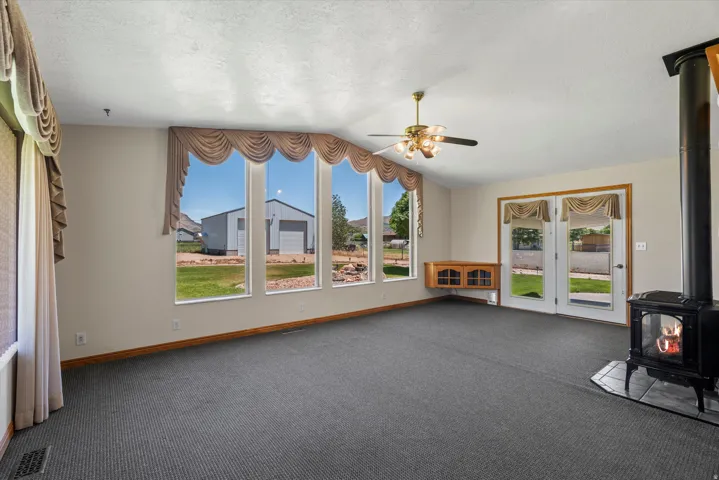 Spacious room featuring multiple large windows and glass French doors, providing abundant natural light