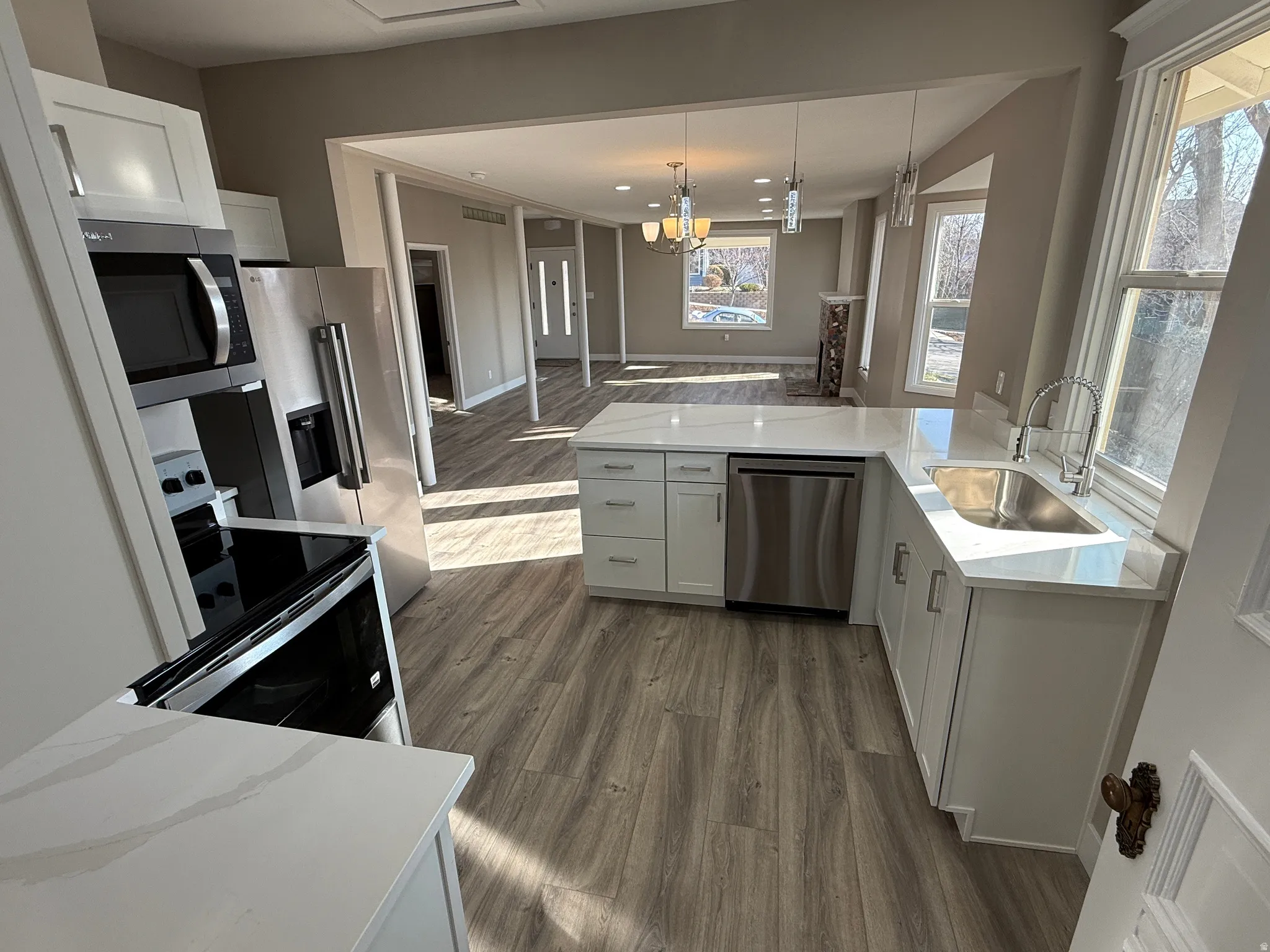 Kitchen featuring a U-shaped layout with white cabinetry, stainless steel appliances, and light-toned countertops
