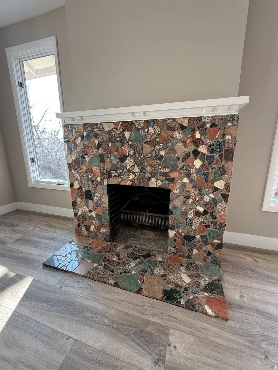 Fireplace featuring a multi-colored stone facade with a decorative white mantel