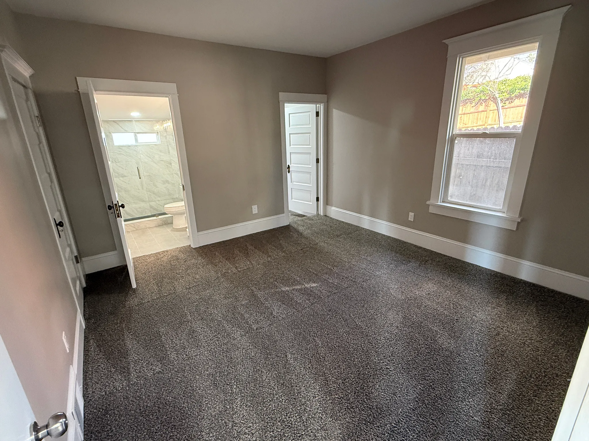 Carpeted room with neutral wall paint and white trim