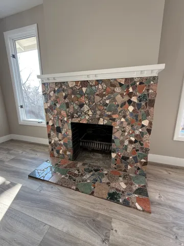 Fireplace featuring a multi-colored stone facade with a decorative white mantel