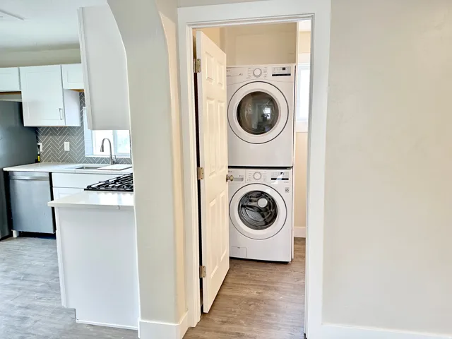 Dedicated laundry area with stacked white appliances