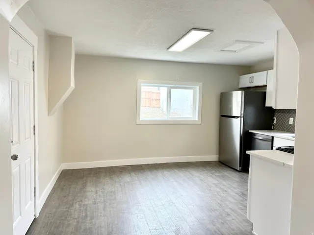 Kitchen and dining area featuring wood-finish flooring, recessed lighting, and a window providing natural illumination