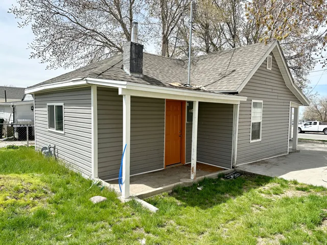 Single-story residence featuring gray horizontal siding and a contrasting orange front door
