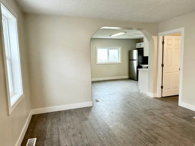 Open-concept living space featuring wood-finish flooring, neutral wall tones, and white trim throughout