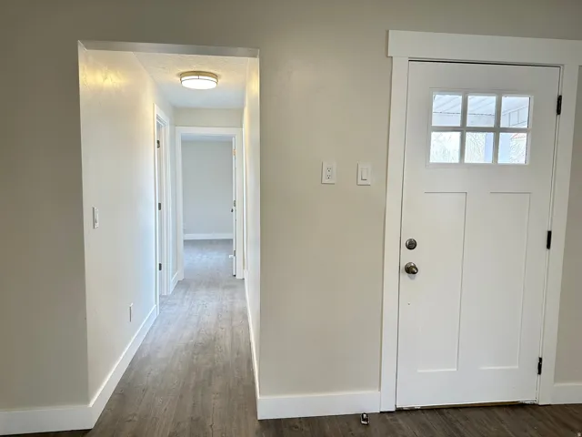 Entryway featuring a white paneled door with glass inserts, wood-finish flooring, and light neutral wall colors