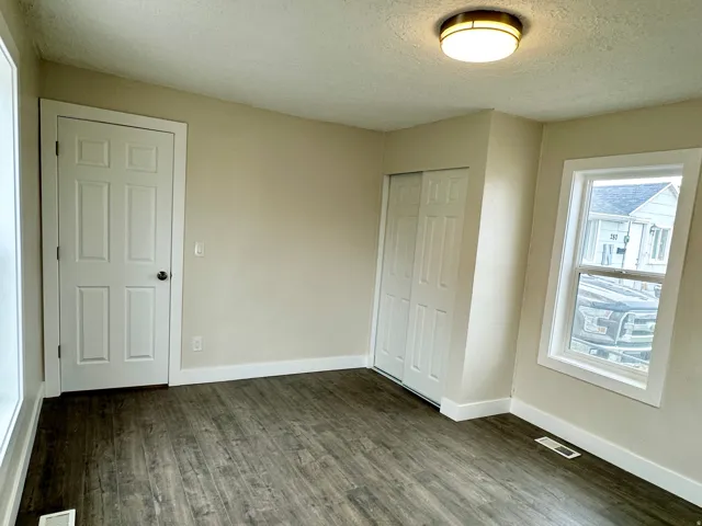 Room featuring wood-finish flooring, neutral wall tones, and white trim