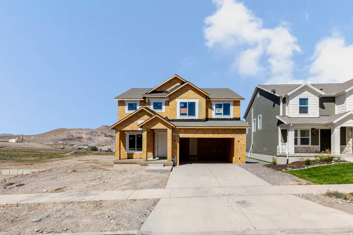 Two-story construction featuring a two-car garage, concrete driveway, and covered entry