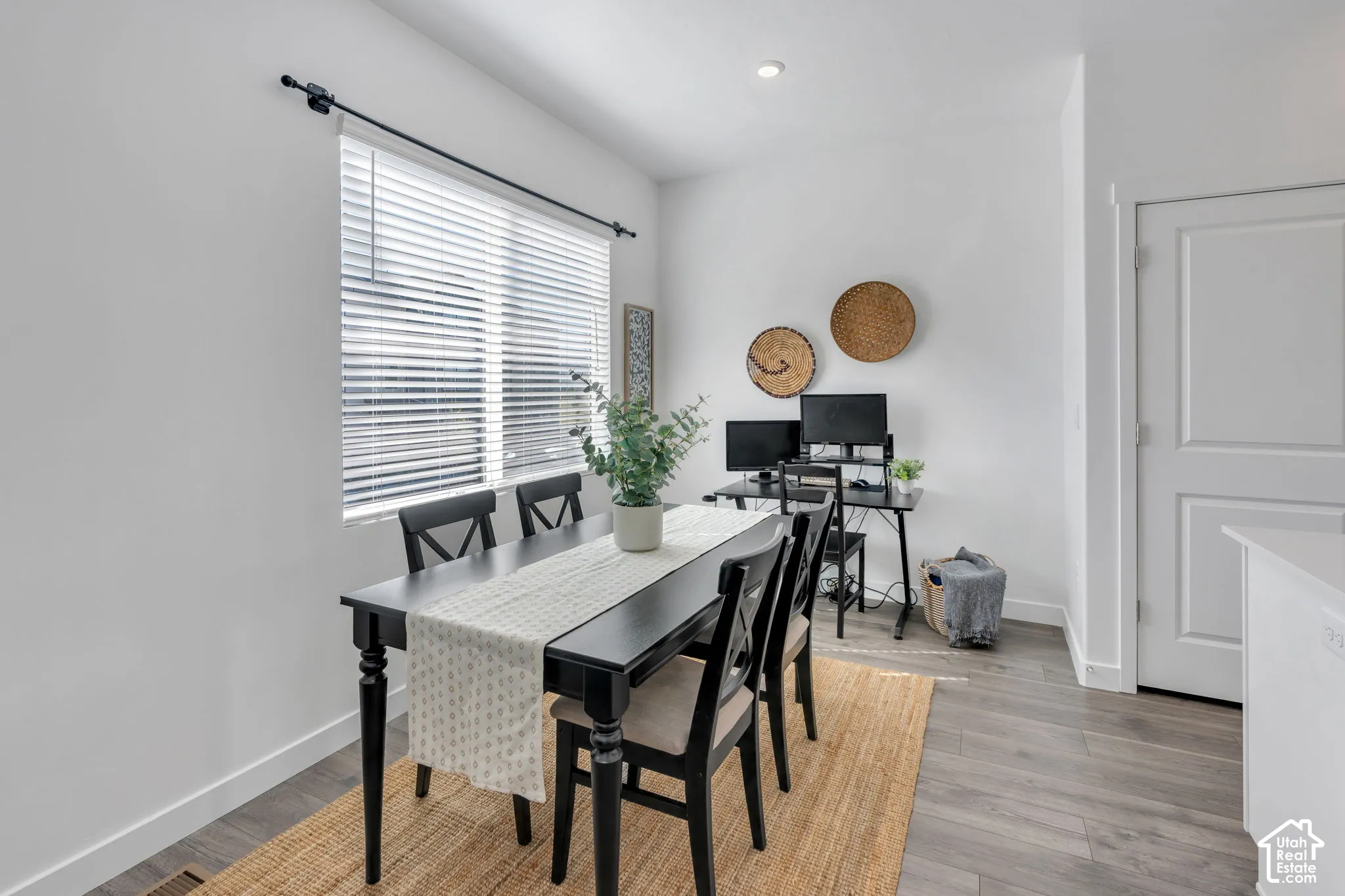 Recessed lighting, window with blinds, wood-finish flooring, and white paneled door