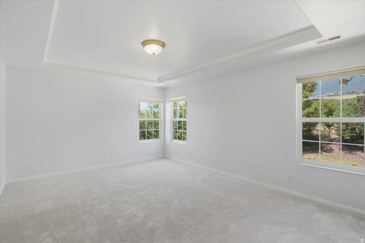 Spacious room featuring light gray carpeting and white walls
