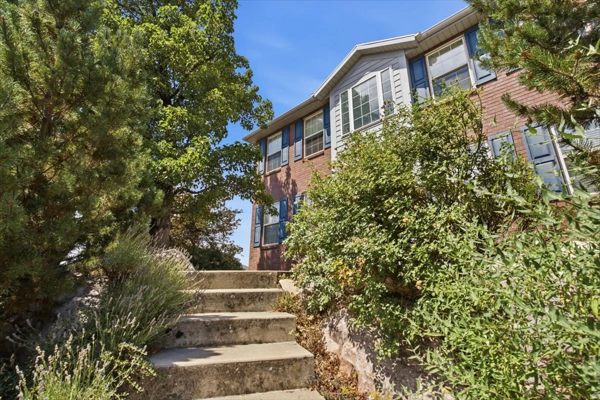 Tiered concrete steps leading to the brick and siding exterior