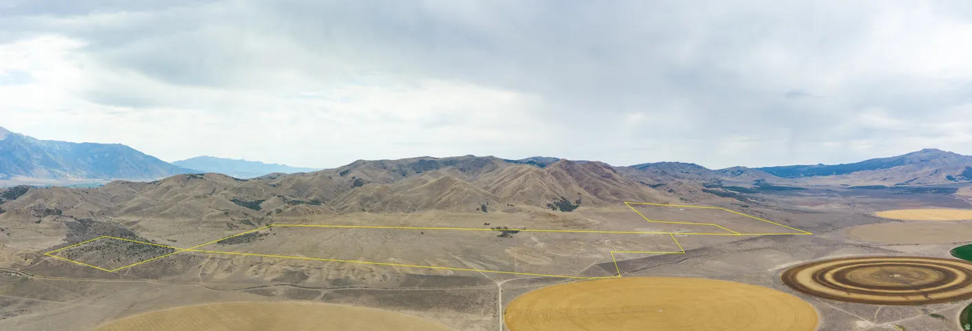 Expansive land parcel featuring defined boundaries, varied terrain, and surrounding agricultural fields