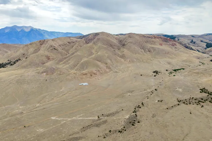 Expansive high desert landscape featuring distant mountains and rolling hills
