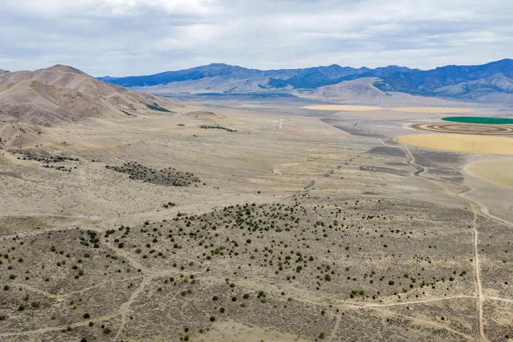 Expansive desert landscape with natural terrain and scattered low-lying vegetation
