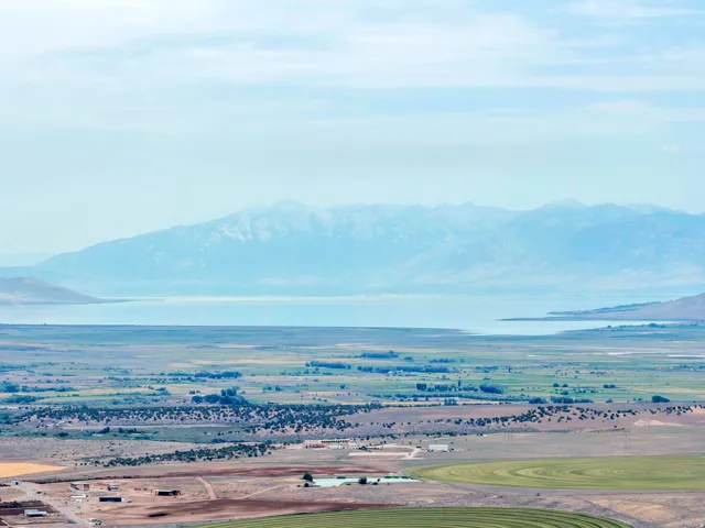 Expansive land featuring distant mountains and a large body of water