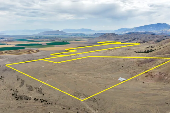 Expansive land parcel outlined in yellow, featuring varied topography including flat areas and rolling hills