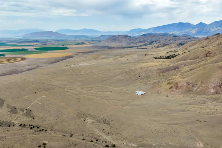 Expansive desert landscape featuring rolling hills and distant mountains