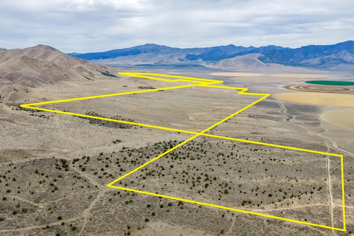 Expansive desert landscape with mountainous terrain and visible distant agricultural fields