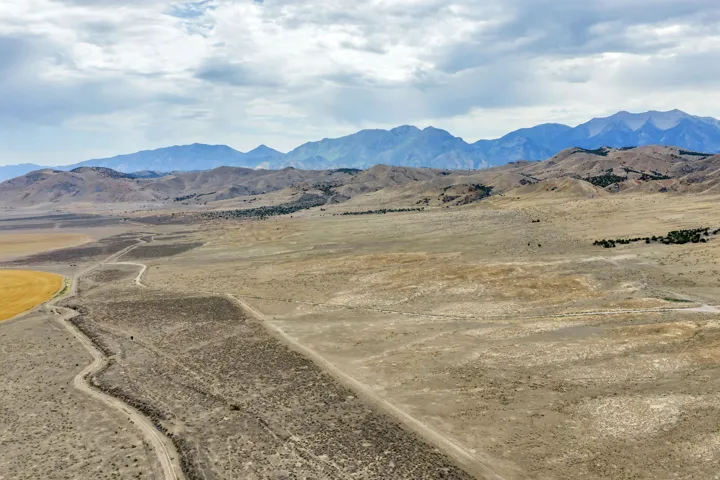 Expansive desert landscape featuring distant mountain ranges under a cloudy sky