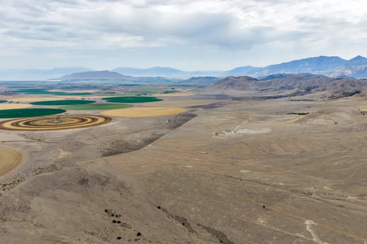 Expansive desert landscape featuring rolling hills and distant mountain ranges