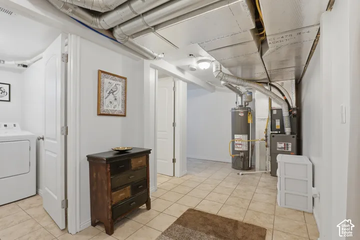 Utility area featuring a water heater, furnace, exposed ductwork, and tile flooring