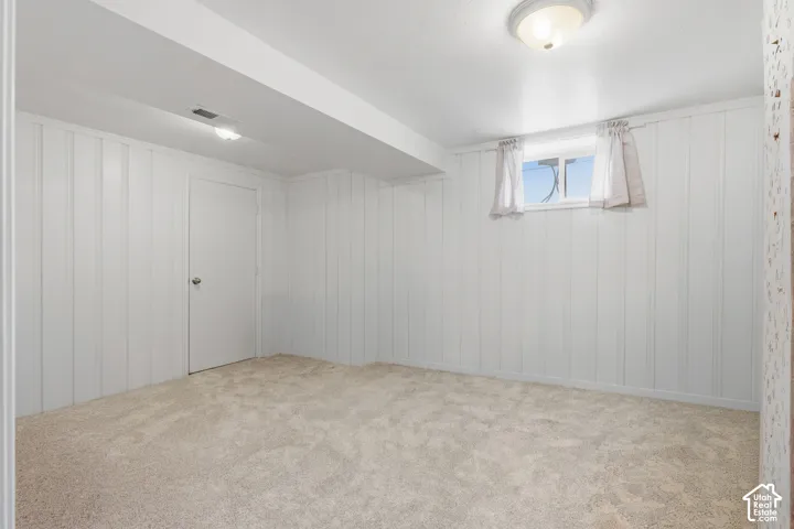 Bright room featuring light-toned carpet flooring and white paneled walls