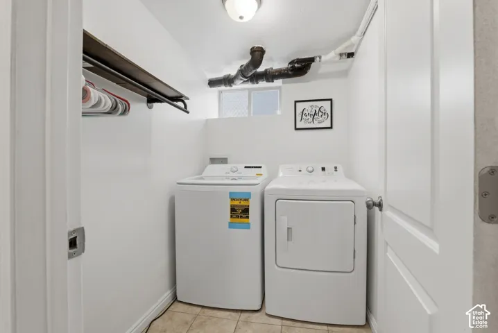 Dedicated laundry area featuring tile flooring and built-in overhead shelving