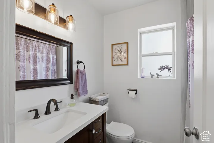 Bathroom featuring a dark wood vanity with white countertop, undermount sink, and oil-rubbed bronze faucet