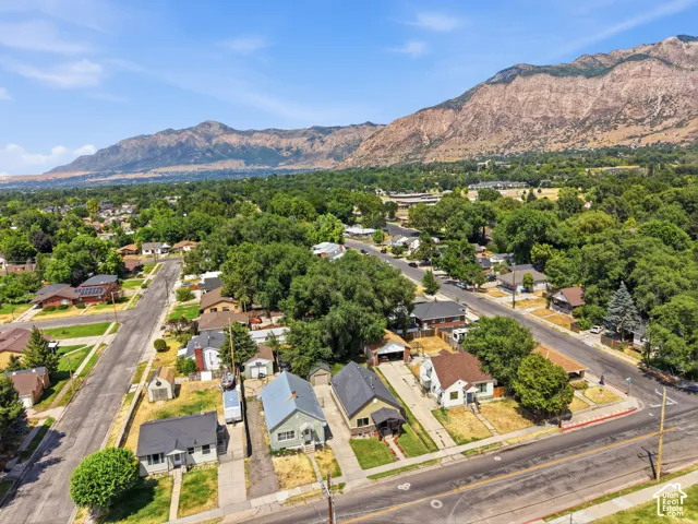 Aerial perspective showcasing a residential neighborhood with established trees and mountain backdrop