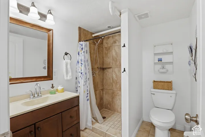 Bathroom featuring a dark wood-finish vanity with a light-toned countertop, an integrated sink, and a framed mirror