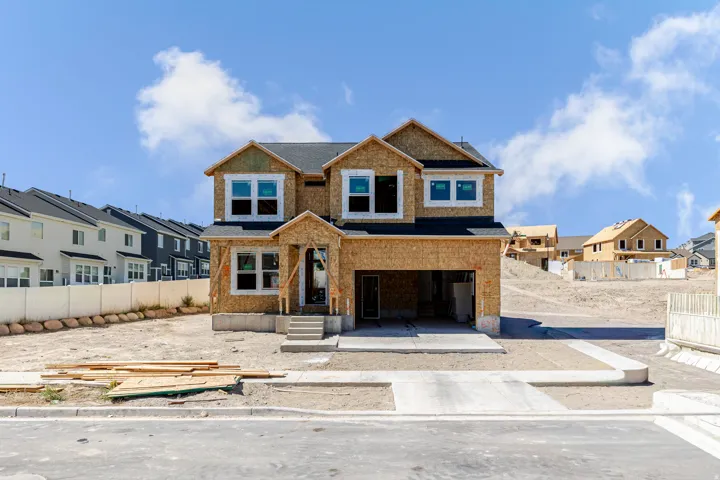 Two-story construction with attached two-car garage, multiple windows, and concrete driveway