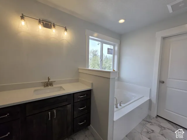 Dark wood-finish vanity with a light-toned countertop, undermount sink, and brushed nickel faucet