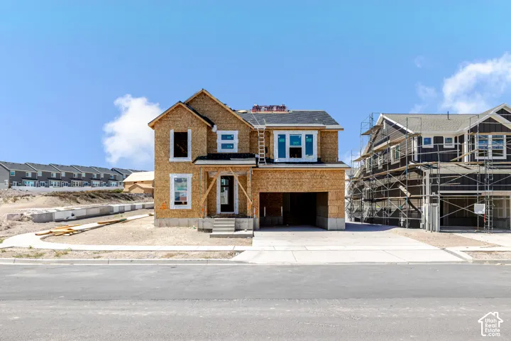 Two-story residential structure with an attached garage, a front porch, and a paved driveway