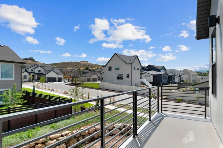 Balcony featuring a metal railing, concrete surface, and exterior wall paneling