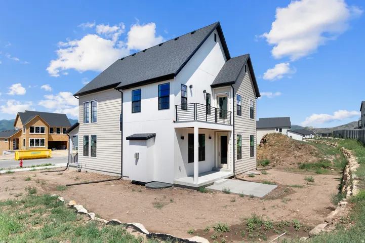Contemporary two-story residence featuring a striking light-colored siding, a dark roofline, and contrasting black-framed windows