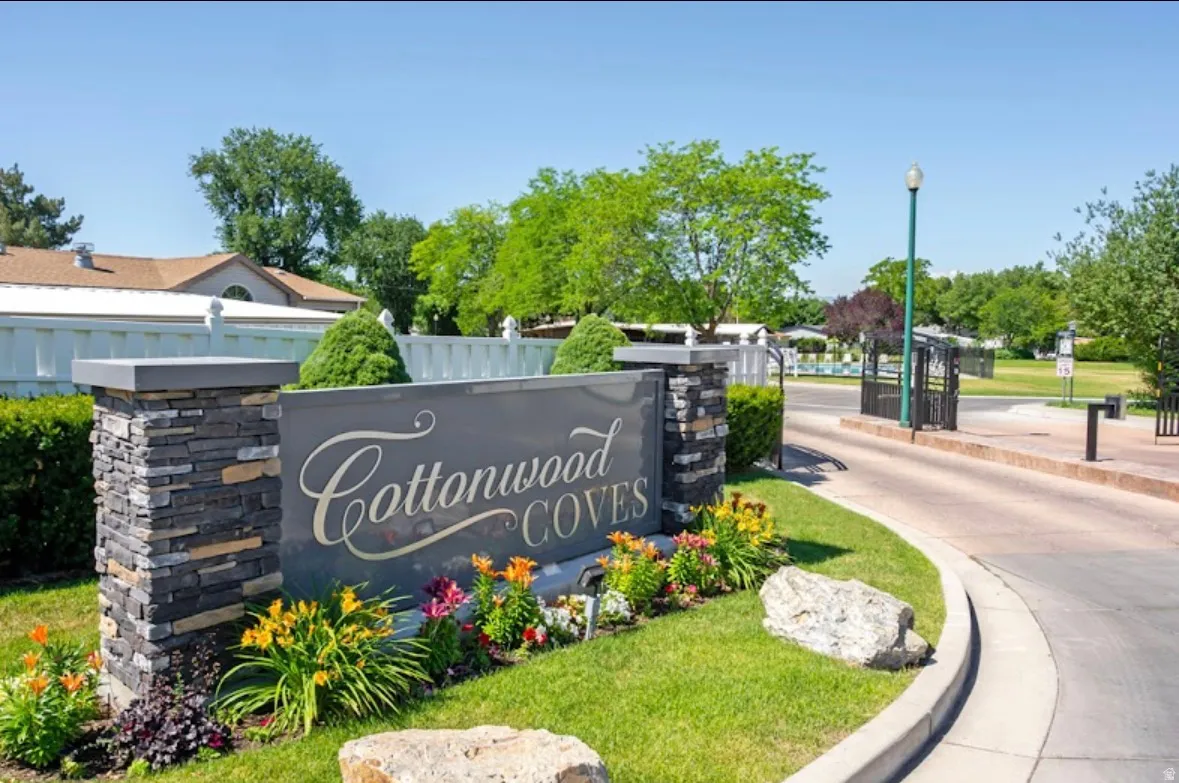 Community entrance featuring a stone veneer monument sign and landscaped flower beds