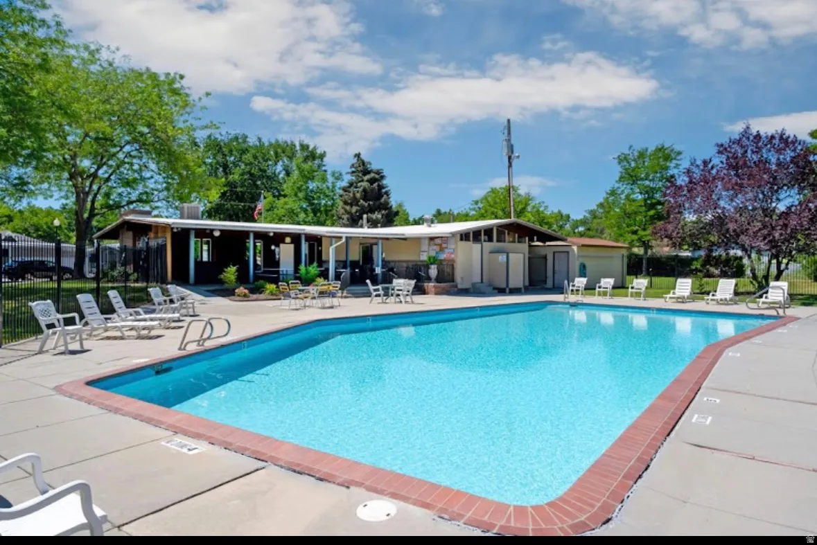 Rectangular outdoor swimming pool featuring a red brick coping and surrounding concrete decking